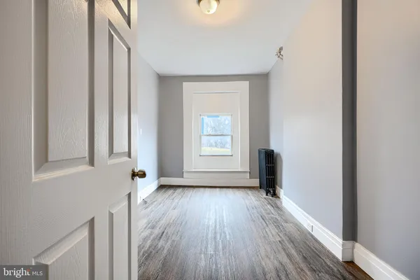 a view of a room with wooden floor and a window