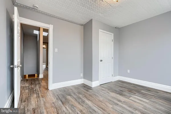 a view of a room with wooden floor and a bathroom
