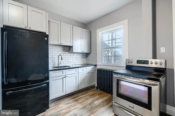 a kitchen with granite countertop a stove top oven and cabinets