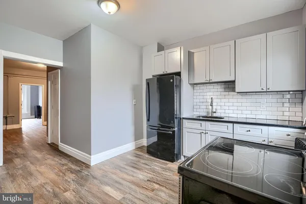 a kitchen with granite countertop a refrigerator stove and sink