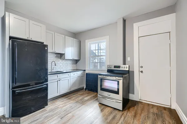 a kitchen with a refrigerator stove and wooden cabinets