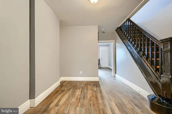 a view of a hallway with wooden floor and staircase
