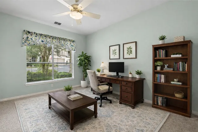 an empty room with a window and a fan