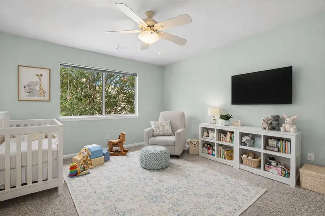 an empty room with windows and fan