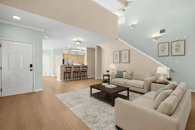 a view of a livingroom with wooden floor and staircase