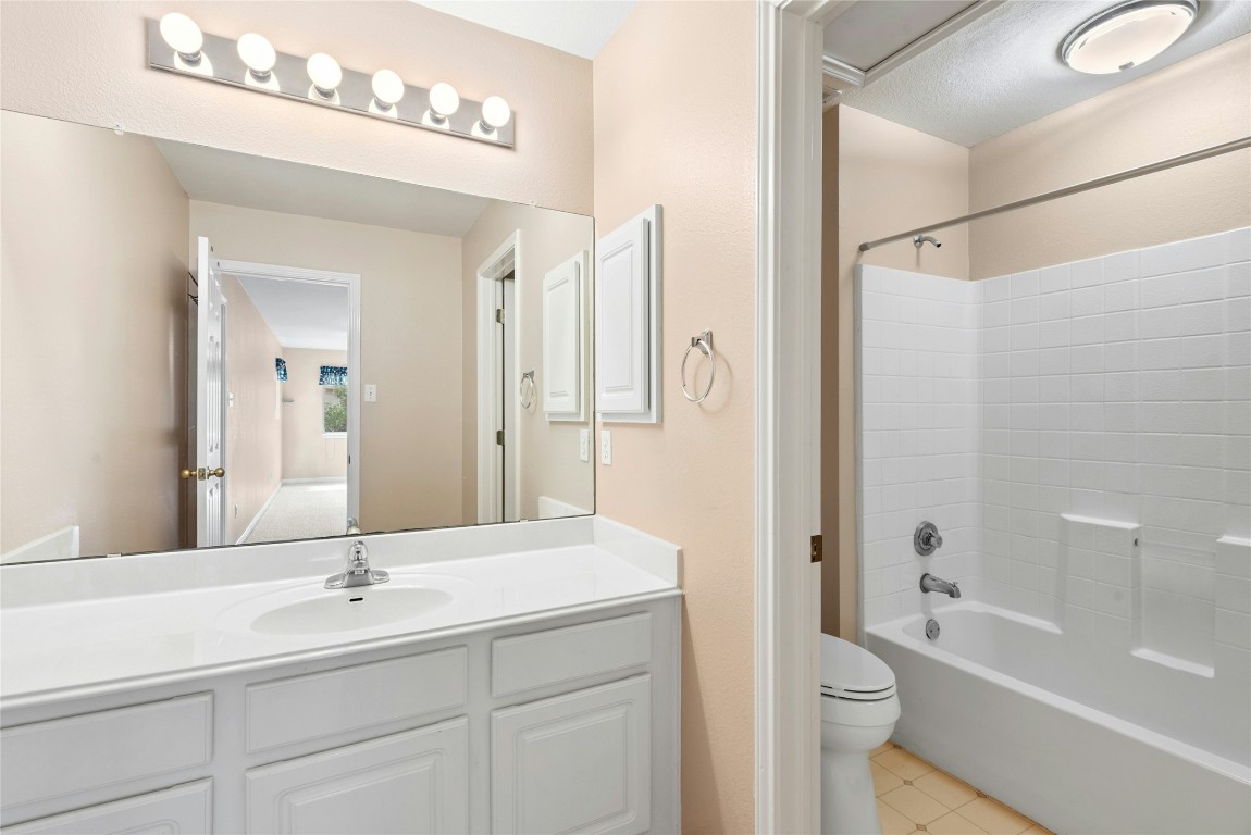 7500 Shadowridge Run, Unit 34 Austin, TX 78749 - Photo 34 of 39 a bathroom with a toilet a sink a mirror a bathtub and vanity