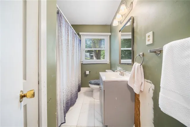 a bathroom with a sink vanity mirror and toilet