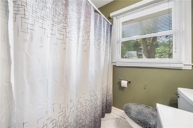 a view of washer and dryer with bathroom in the background