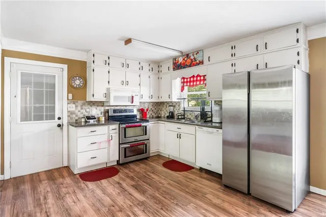 a kitchen with granite countertop stainless steel appliances a refrigerator and counter space