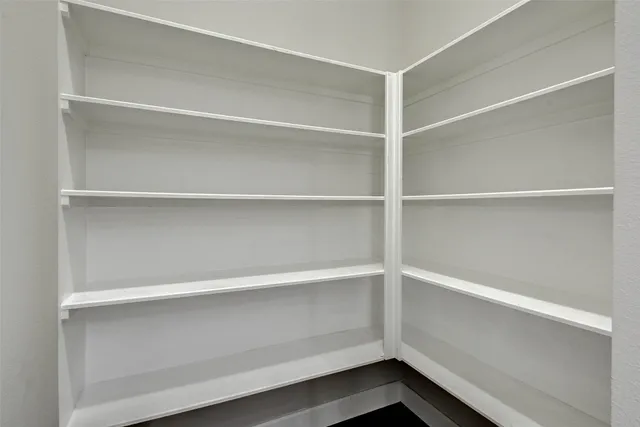 an empty room with wooden floor ceiling fan and windows