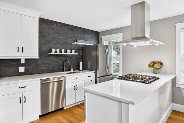 a view of a bedroom with a bed and wooden floor