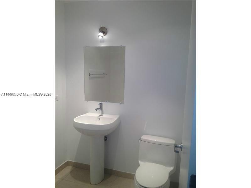 3301 Northeast 1st Avenue, Unit H2408 Miami, FL 33137 - Photo 10 of 10 a bathroom with a toilet sink and a mirror