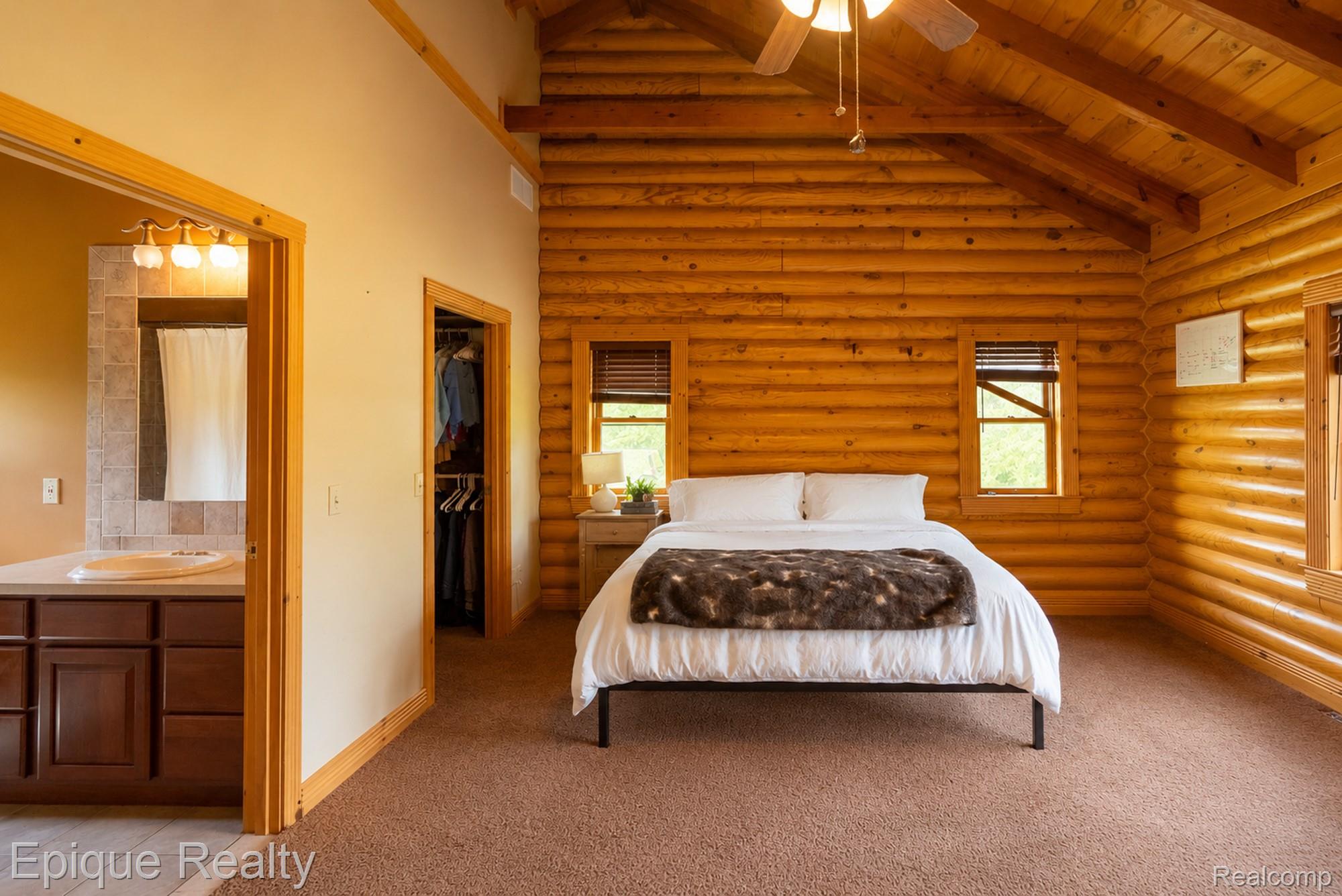 1966 Mayer Road Smiths Creek, MI 48074 - Photo 12 of 38 Vaulted wood plank ceilings with exposed beams and a ceiling fan complement the log-style walls