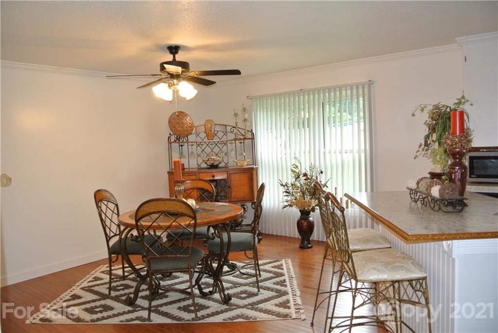 137 Cedar Lane Rutherfordton, NC 28139 - Photo 10 of 26 a dining room with chandelier fan and wooden floor