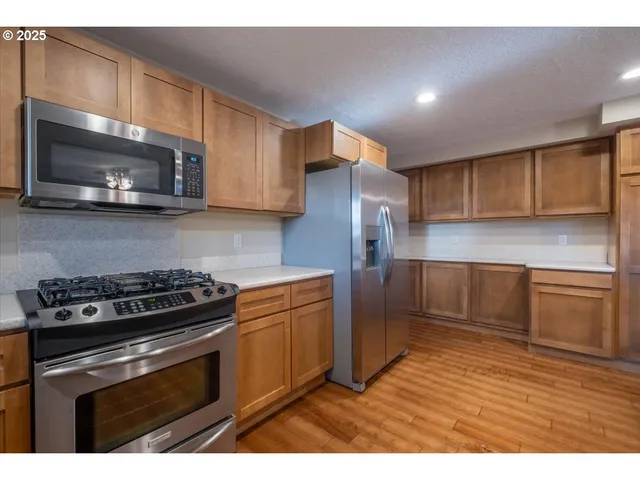 a kitchen with stainless steel appliances granite countertop a stove microwave and sink