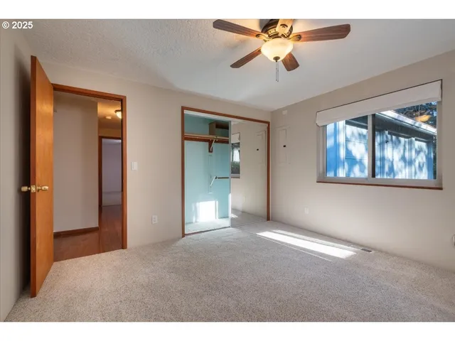 a view of an empty room with a chandelier fan