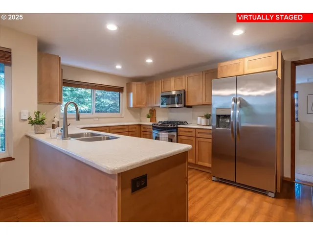 a kitchen with kitchen island a counter top space a sink stainless steel appliances and cabinets