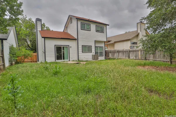 a view of a yard in front of a house with large tree