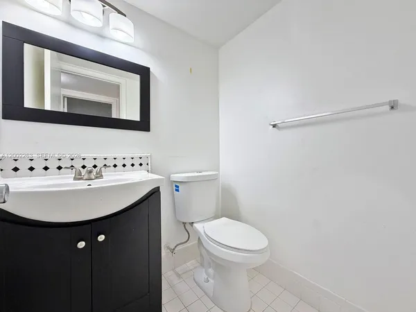 a bathroom with a toilet a sink and mirror