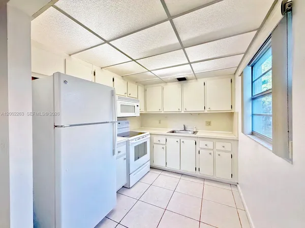 a kitchen with cabinets a refrigerator and a sink