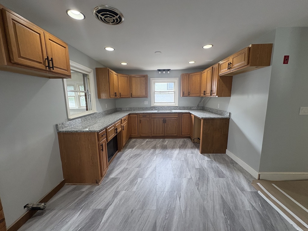 764 Hancock Street, Unit 2 Quincy, MA 02170 - Photo 2 of 6 a kitchen with wooden floors and wooden cabinets