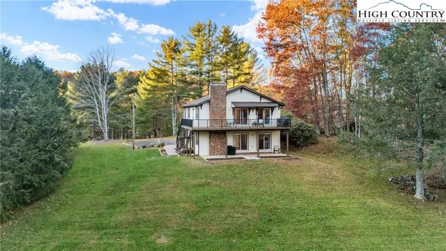 a view of a house with a big yard and large trees