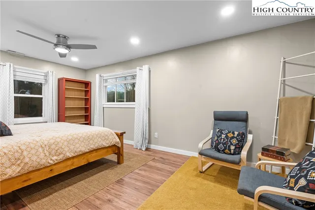 a bedroom with a bed lamp on desk and a window