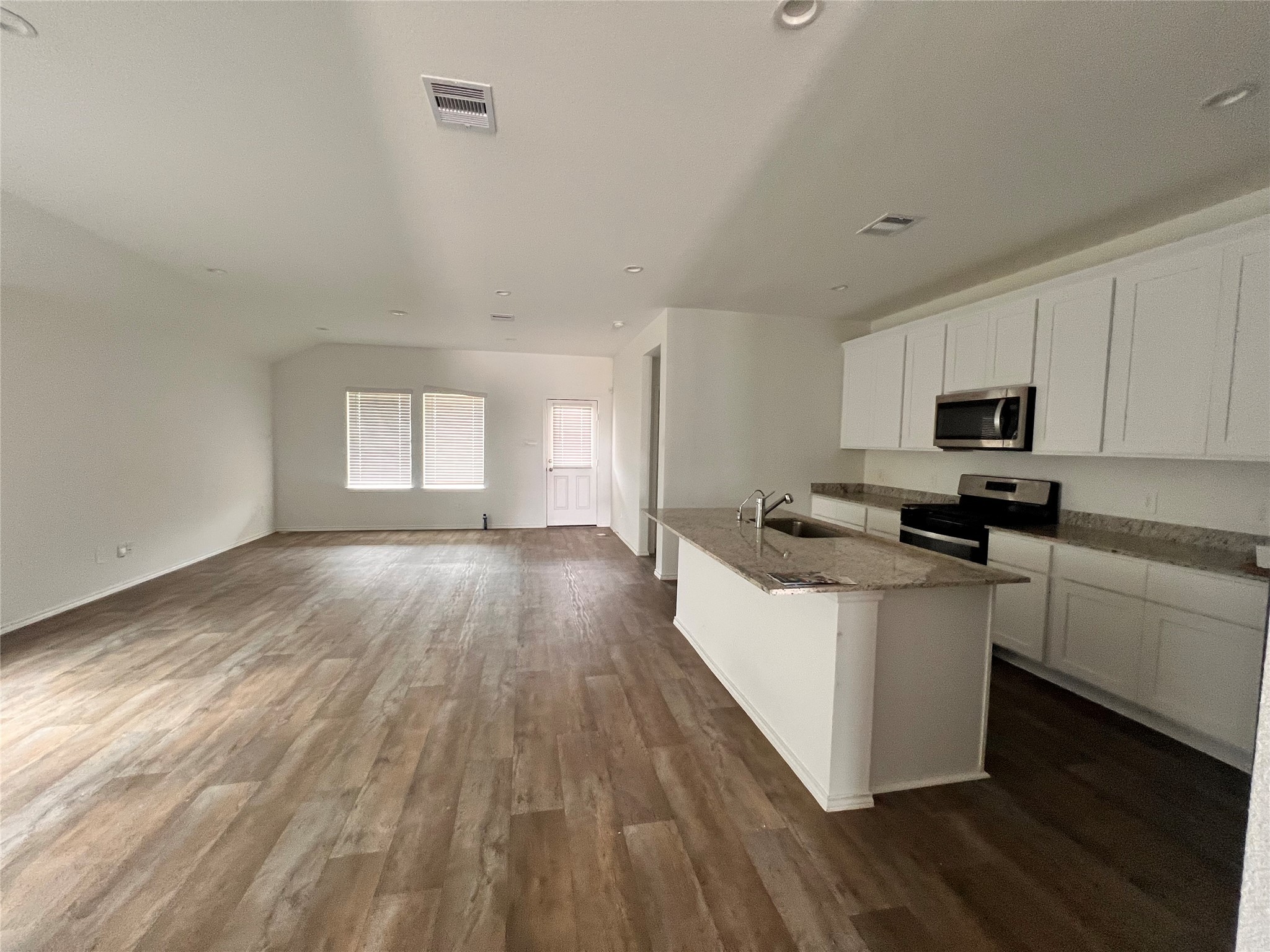 3826 Lanercost Lane Fulshear, TX 77441 - Photo 7 of 29 a kitchen with wooden floors and white appliances