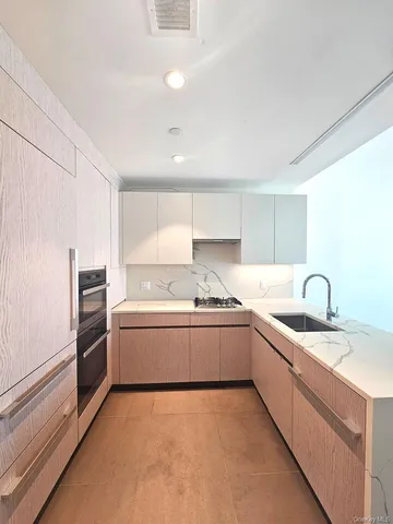 a kitchen with stainless steel appliances granite countertop a sink and a stove