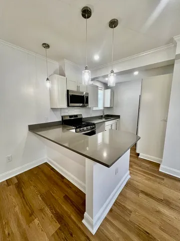 a kitchen with kitchen island a counter space a sink and appliances