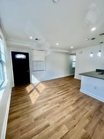 a view of empty room with wooden floor