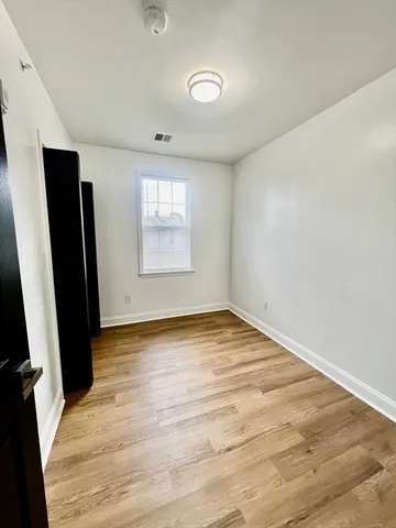 an empty room with window and wooden floor