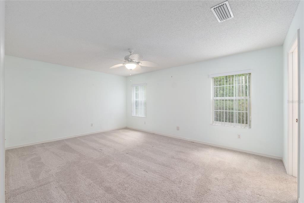 5393 Southwest 109th Place Road Ocala, FL 34476 - Photo 22 of 54 an empty room with a chandelier fan and windows