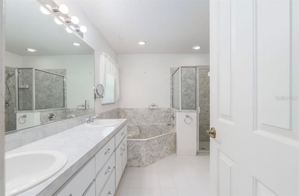 5393 Southwest 109th Place Road Ocala, FL 34476 - Photo 23 of 54 a spacious bathroom with a double vanity sink a mirror and a bathtub