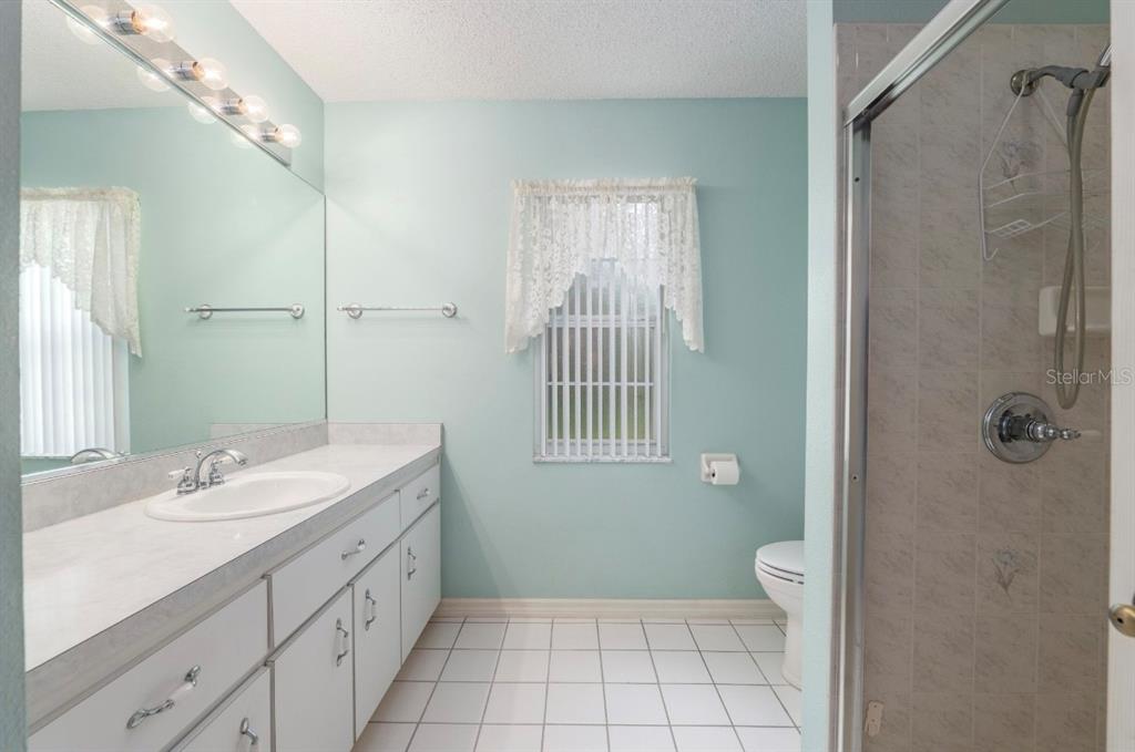 5393 Southwest 109th Place Road Ocala, FL 34476 - Photo 28 of 54 a spacious bathroom with a double vanity sink toilet and shower