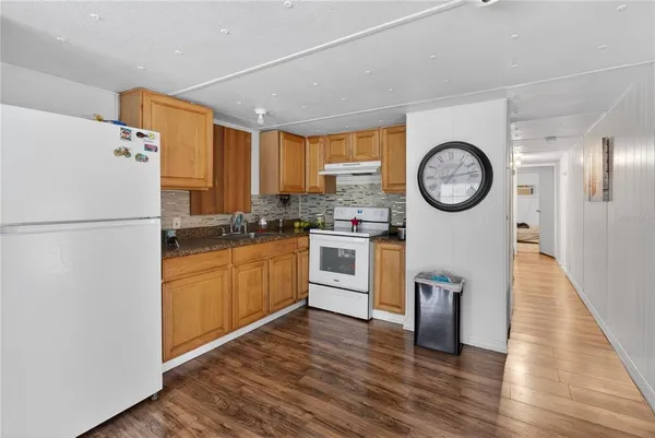 a kitchen with a refrigerator and a stove top oven