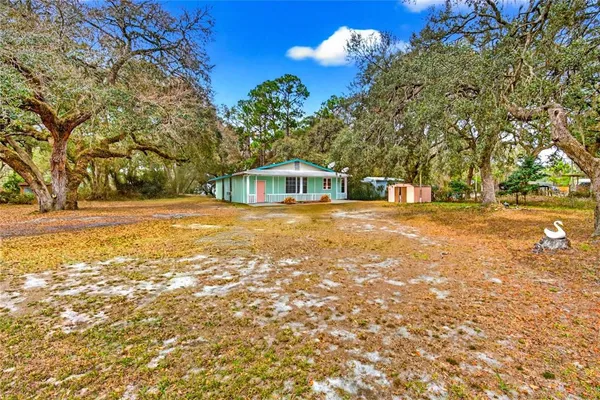 a view of a house with a yard and sitting area
