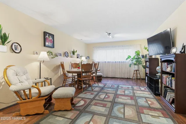a living room with furniture a flat screen tv and a table