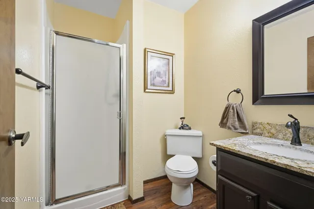 a bathroom with a granite countertop sink toilet and a mirror