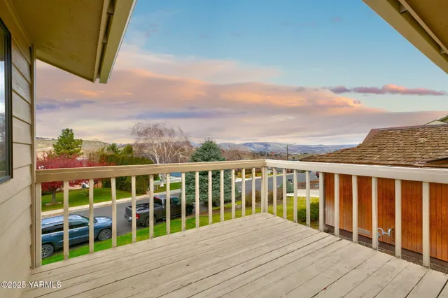 a view of a balcony with wooden floor and fence