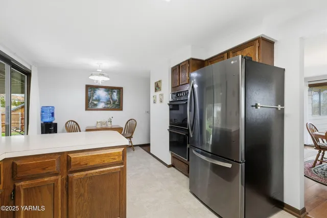 a kitchen with stainless steel appliances granite countertop a refrigerator a stove and a sink with wooden floor