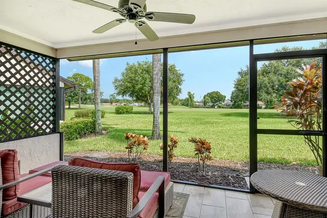 a living room with furniture a flat screen tv and a floor to ceiling window