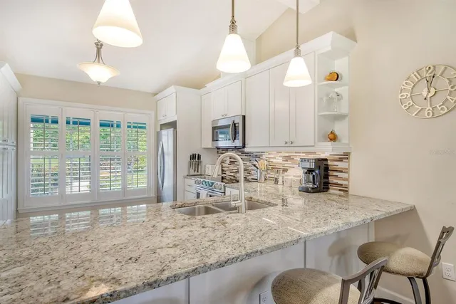 a view of a kitchen with a sink a large window and a rug