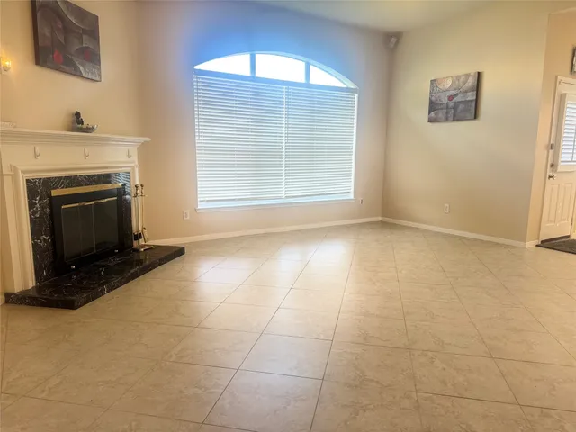 a view of an empty room with a fireplace and a window