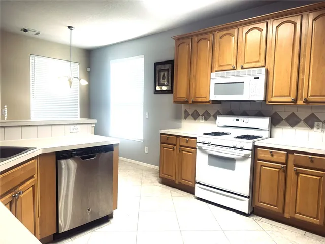 a kitchen with a stove sink and cabinets