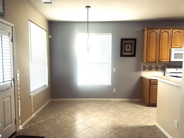 a view of storage and utility room with window and refrigerator