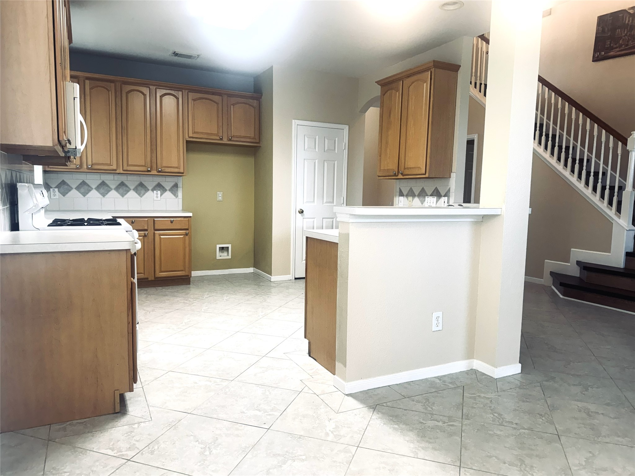 9810 Mossy Tree Lane Houston, TX 77064 - Photo 10 of 24 a kitchen with a stove a sink and a refrigerator