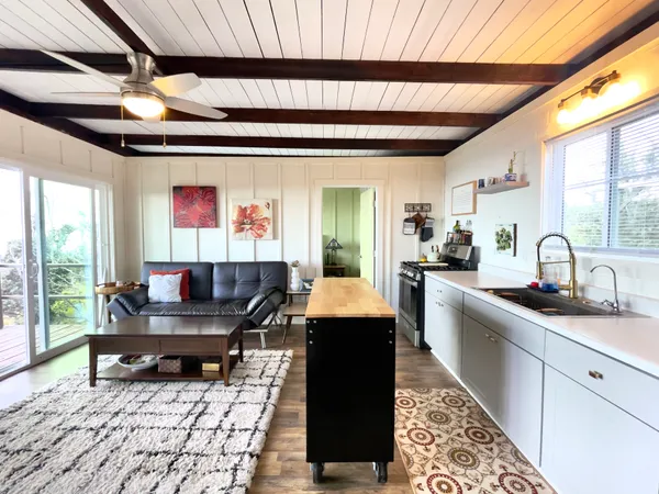 a dining hall with granite countertop a sink a rug a dining table and chairs with wooden floor