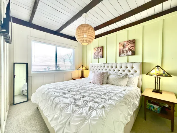 a bedroom with a bed and a painting on the wall