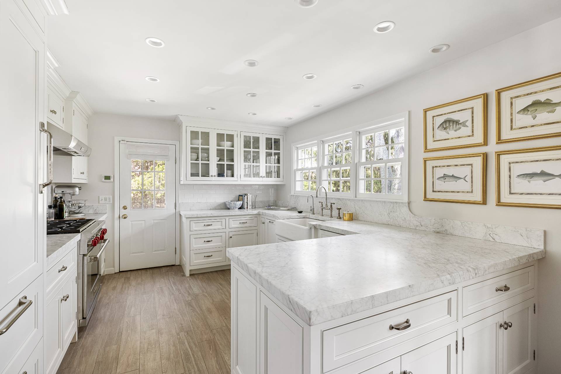 429 Head Of Pond Road Water Mill, NY 11976 - Photo 6 of 22 a kitchen with a stove a sink a refrigerator and white cabinets with wooden floor